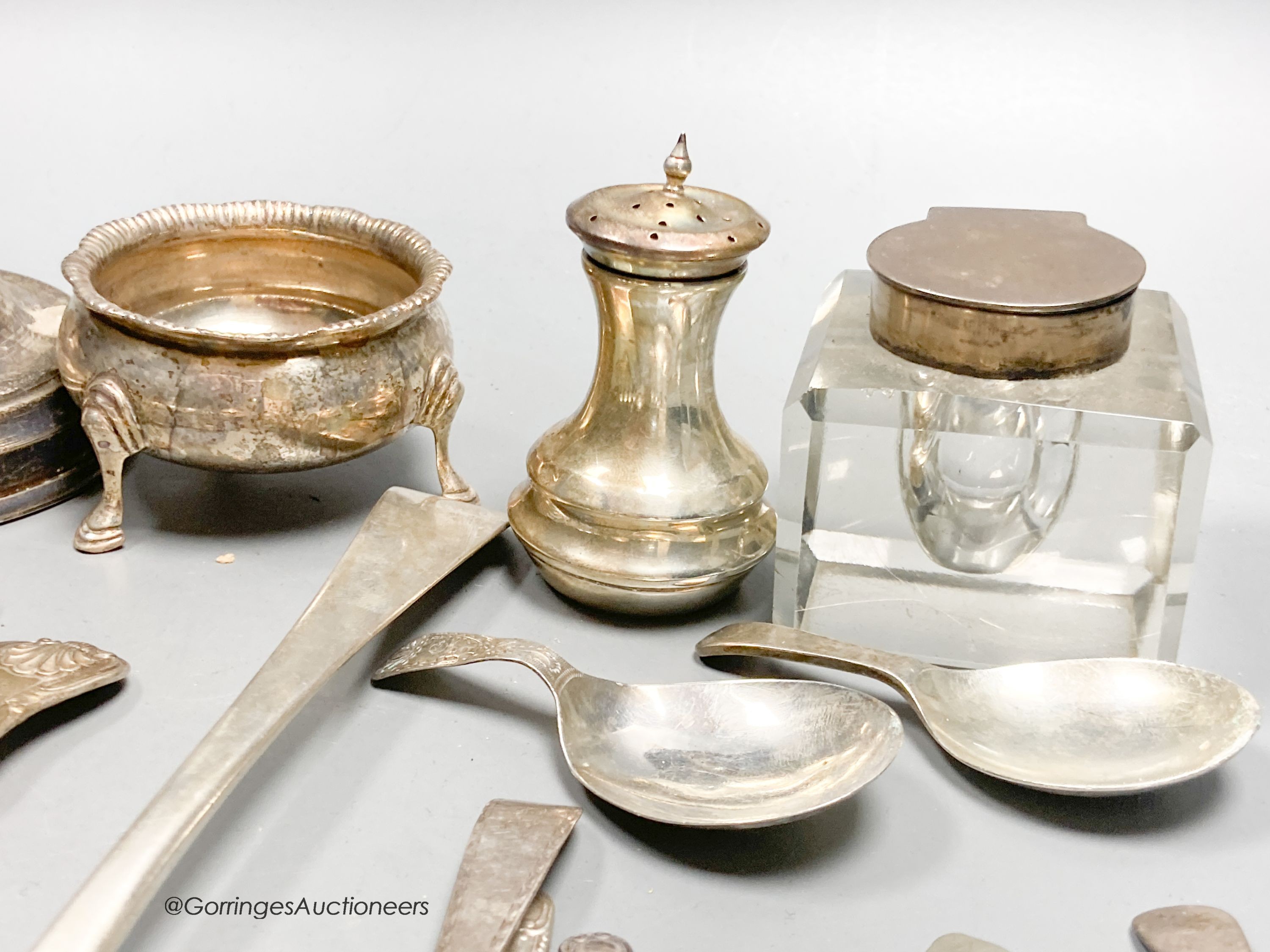 A collection of small silver, including a George V silver mustard, continental white metal and English silver flatware, toastrack, salt, inkwell etc. and a plated candlestick.